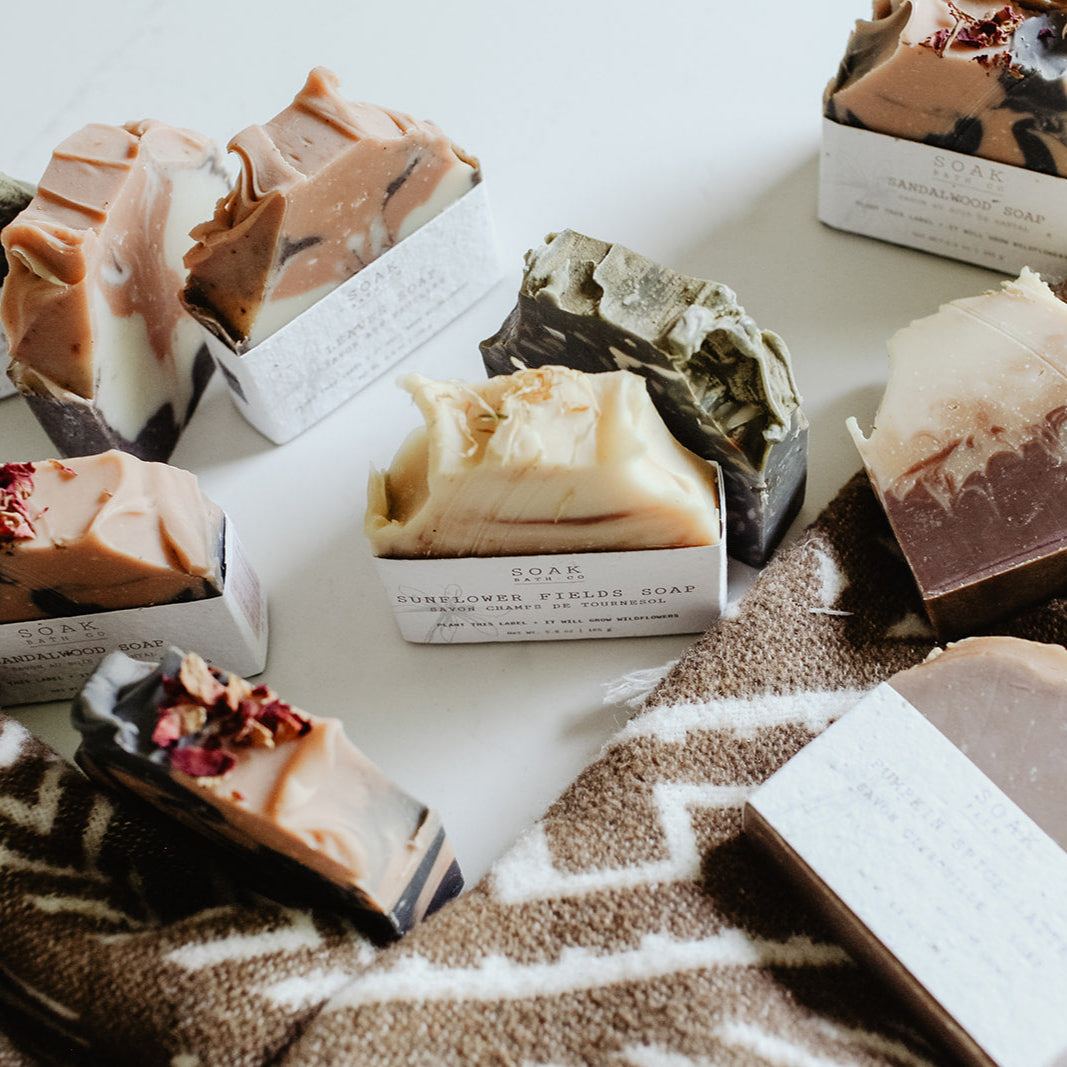 Assorted soaps on a textured surface with a neutral background