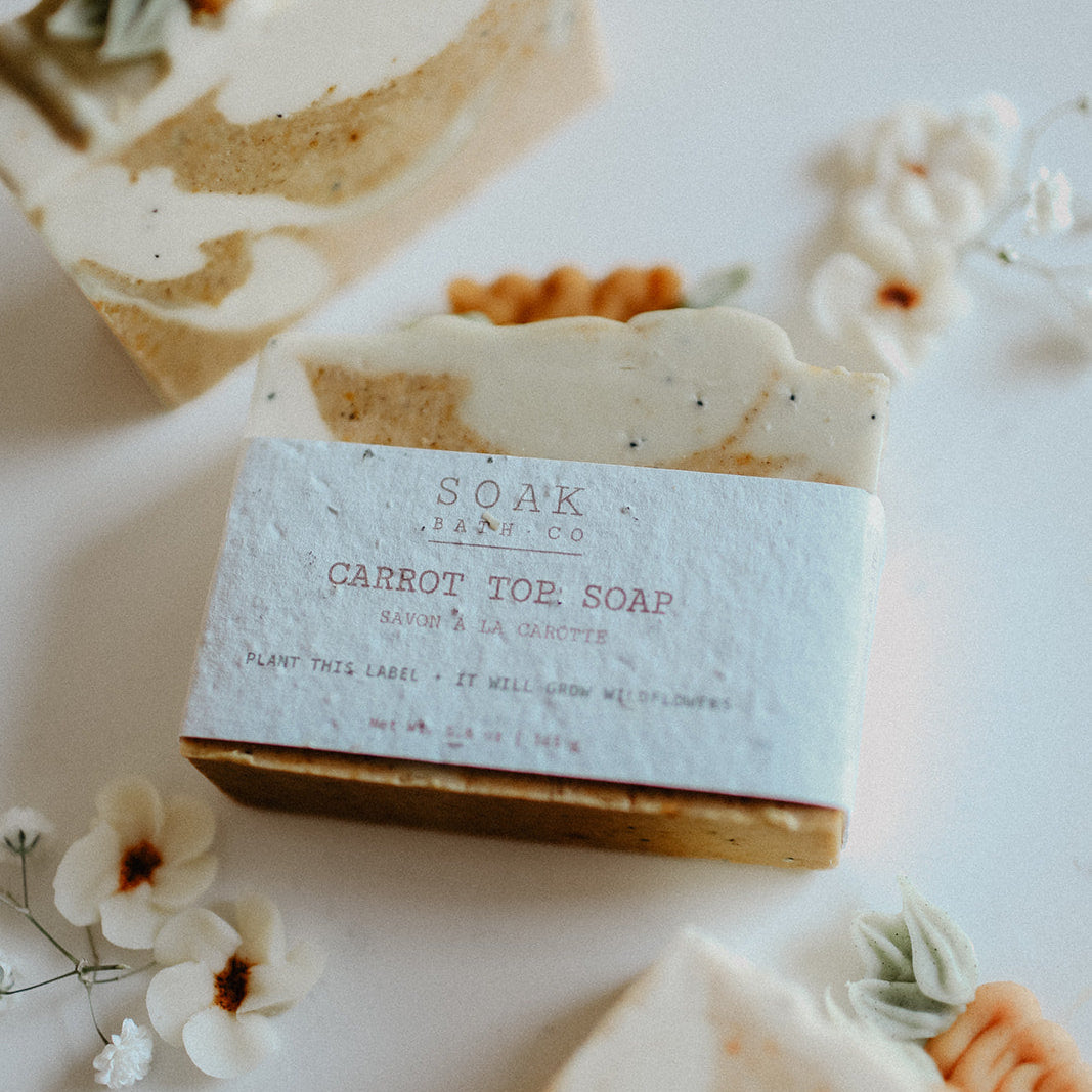 Bar of soap with a label on a white surface with flowers