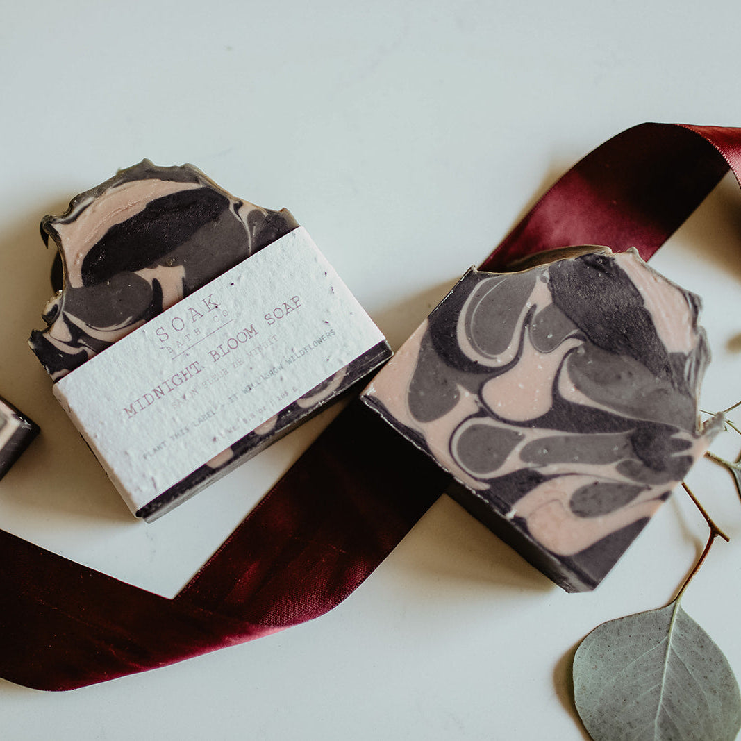 Marble-patterned soap bars with a red ribbon on a light surface