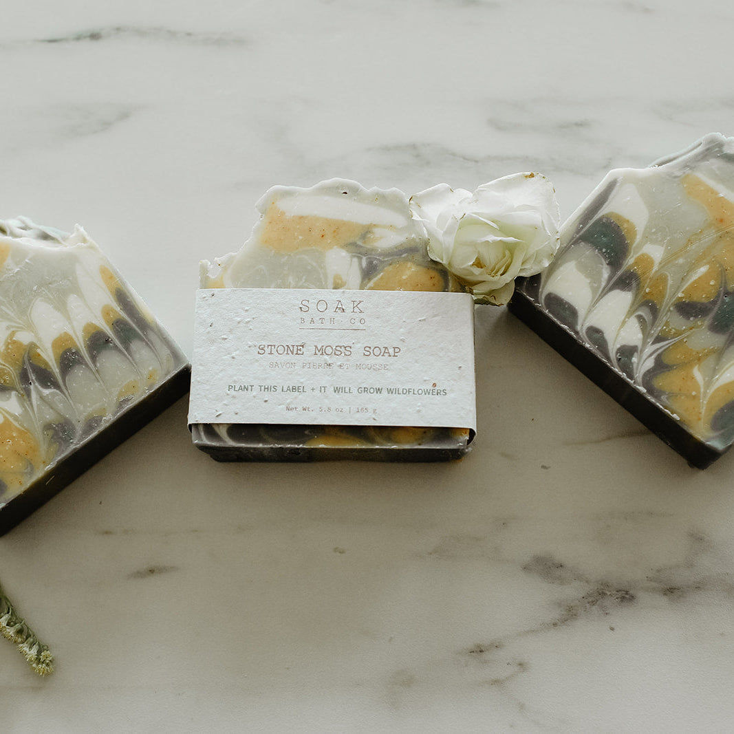 Three bars of soap with marbled design on a marble surface