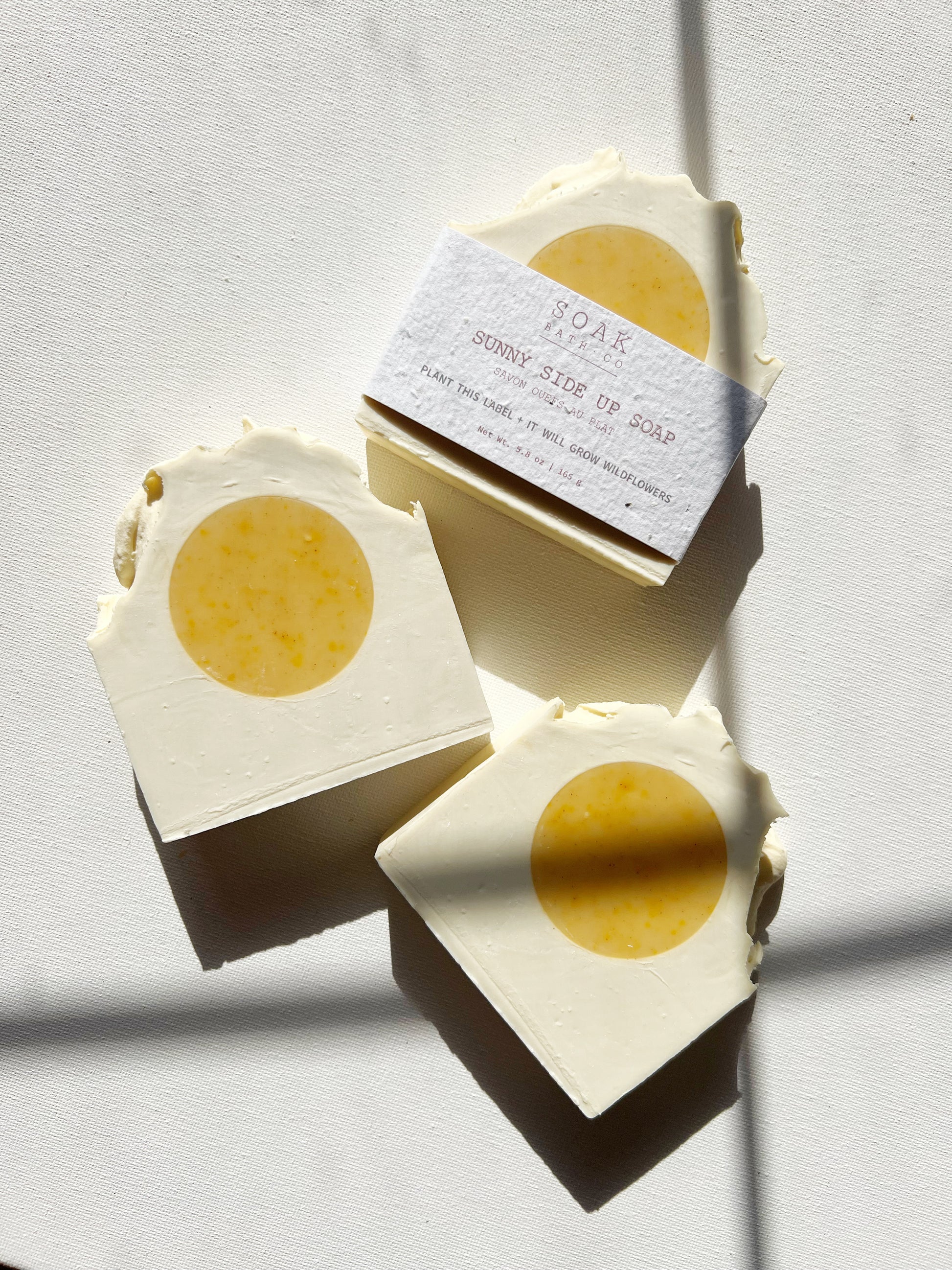 Three bars of soap with yellow centers on a light gray background