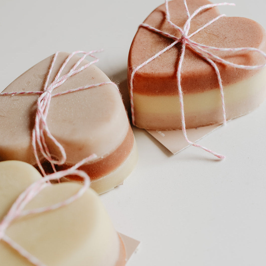 Heart-shaped soap bars wrapped with string on a light background